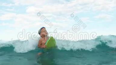 小男孩试图用游泳板慢动作捕捉波浪